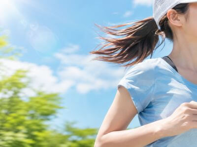 キャップを被ってランニングしている女性