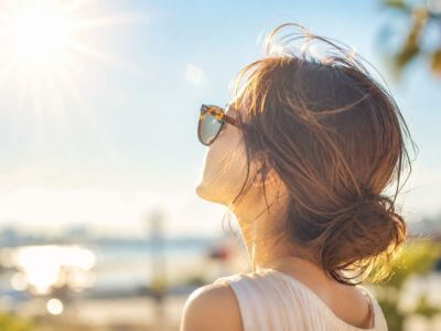 太陽の下でサングラスをかけている女性